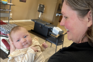Chiropractor holding newborn baby.